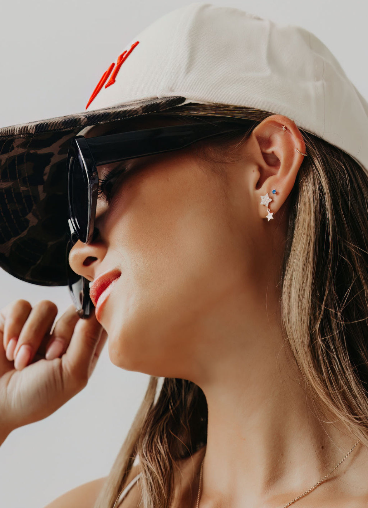 woman with stylish earrings on and a hat